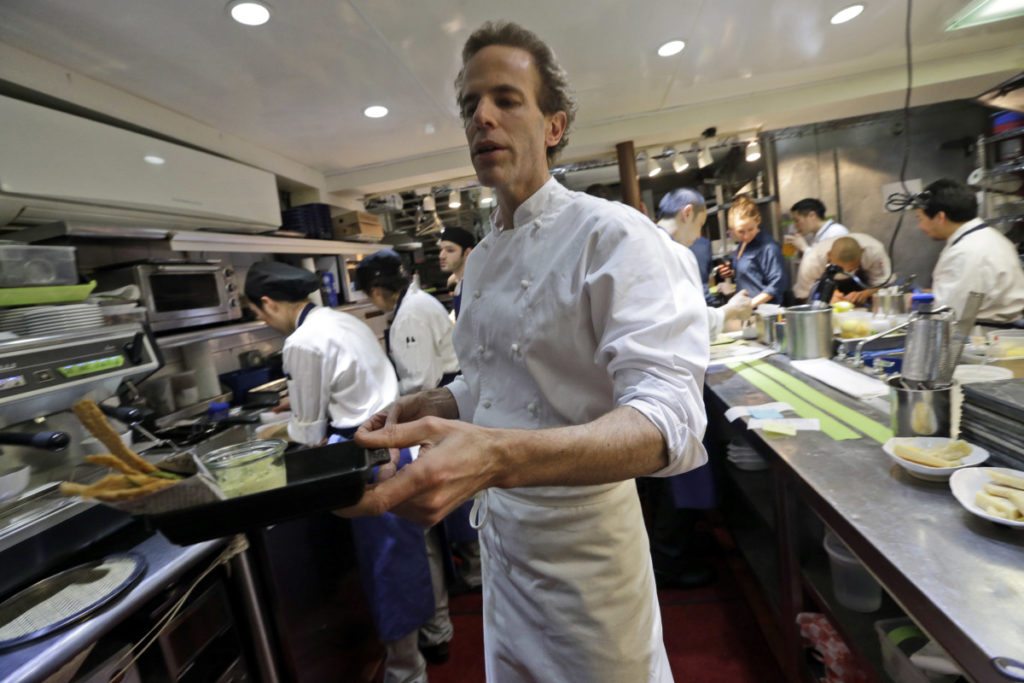 In this Thursday, March 19, 2015 photo, chef Dan Barber hands a waiter an order of fried skate wing cartilage with smoked whitefish head tartar sauce at WastED in New York. Dishes using scraps and other ignored bits comprise the menu at chef Dan Barber's WastED, a pop-up project at one of his Blue Hill restaurants intended to shed light on the waste of food. (AP Photo/Mary Altaffer)